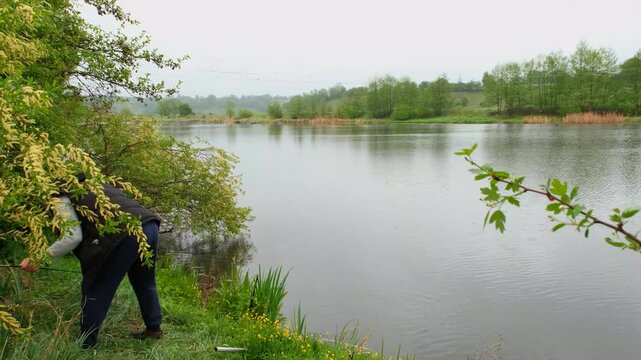 Professional fisherman casting a spinning rod into the lake.