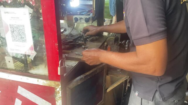 Skilled craftsman duplicating keys and locks at a small workshop counter
