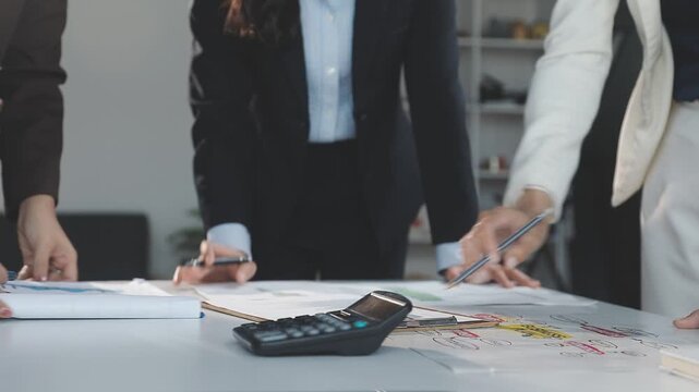 Two Businessman Calculating Bills Using Calculator At Workplace. Business team meeting and discussing project plan. Businessmen discussing together in meeting room