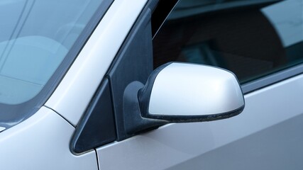 Side view mirror on a silver car.
