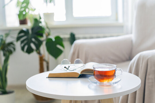 Relaxing with tea and reading a book indoors