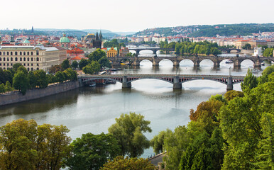 Fototapeta premium Charles Bridge (Karlův most) in Prague, Czech Republic, spanning the Vltava River with historic towers and Gothic architecture. Panoramic view of the medieval bridge and city skyline, iconic European 
