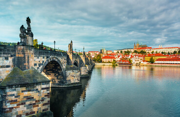 Fototapeta premium Charles Bridge (Karlův most) in Prague, Czech Republic, spanning the Vltava River with historic towers and Gothic architecture. Panoramic view of the medieval bridge and city skyline, iconic European 