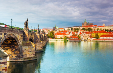 Naklejka premium Charles Bridge (Karlův most) in Prague, Czech Republic, spanning the Vltava River with historic towers and Gothic architecture. Panoramic view of the medieval bridge and city skyline, iconic European 