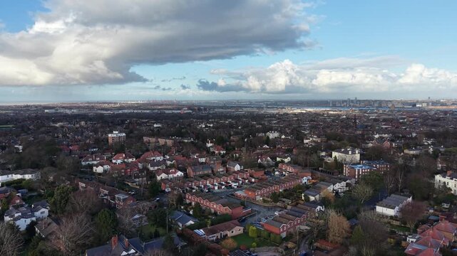 Cinematic aerial tracking shot moving over suburban housing, green spaces and tree‑lined roads in Wirral, Merseyside. Suitable for planning proposals, environmental studies and regional development co