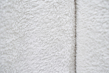 Close-up texture of soft white plush fabric showing detailed surface and cozy appearance. © elenavolf