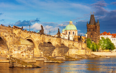 Fototapeta premium Charles Bridge (Karlův most) in Prague, Czech Republic, spanning the Vltava River with historic towers and Gothic architecture. Panoramic view of the medieval bridge and city skyline, iconic European 