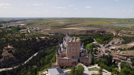 Fototapeta premium Drone Aerial of Alcázar de Segovia Contrasting with the Landscape, Spain