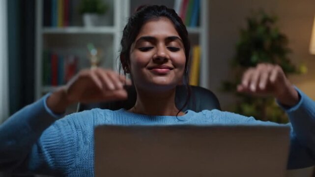 Young woman working intensely on laptop at home in the evening