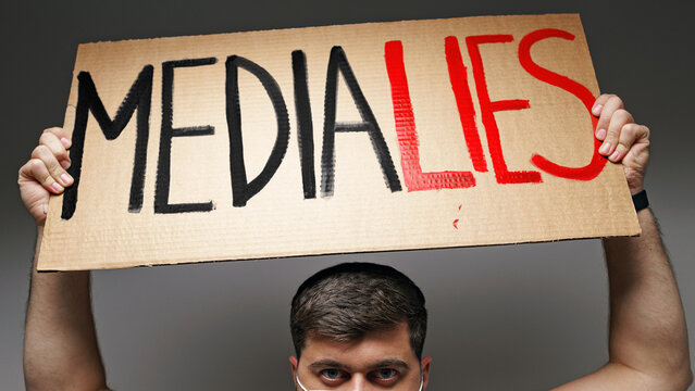 Protester holds sign saying media lies during demonstration showing public dissent