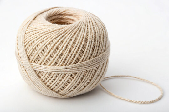 A natural beige twine ball with a loose end, isolated on a clean white background, showcasing rustic texture for crafts, packaging, and DIY