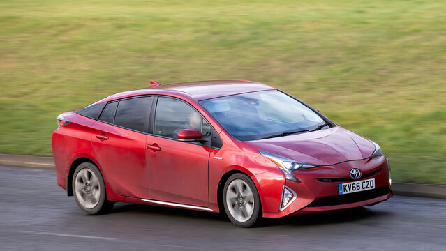 Milton Keynes,Bucks,UK - Jan 28th 2026:   2016 red Toyota Prius hybrid electric car driving on a British road