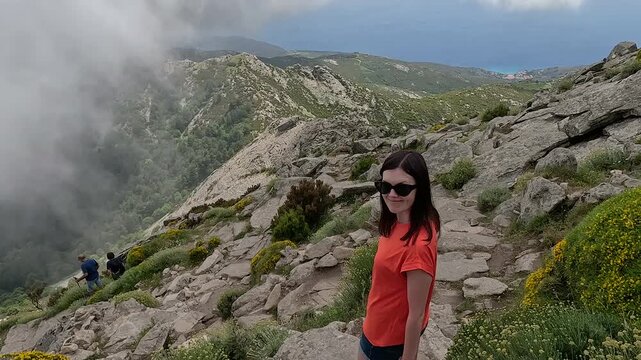A woman descends from a high mountain on the island of Elba.