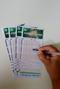 Salvador, Brazil - February 15, 2026: Vertical shot of a person filling out a Mega-Sena lottery ticket. Loterias Caixa Mega Sena. Brazilian Lottery. 