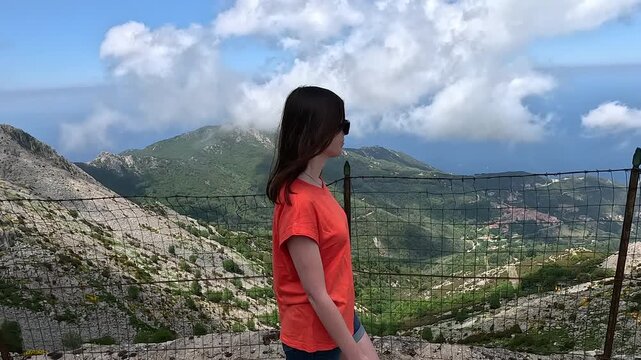 A woman looks out from a viewing platform on a mountain on Elba Island.