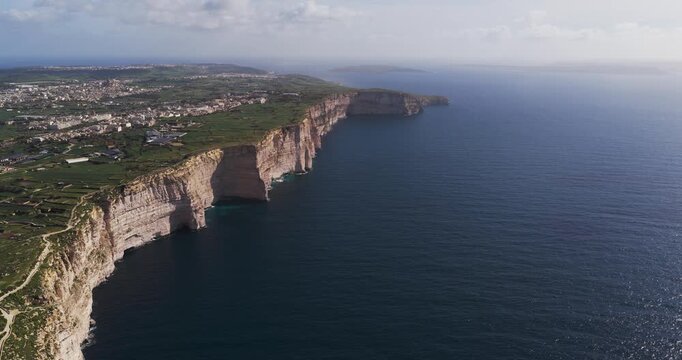 Aerial view of the rugged Xlendi coastline, where sheer cliffs meet the deep blue sea in a stunning display of nature's power, Xlendi, Munxar, Malta.