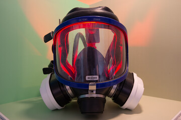 Exterminator&rsquo;s face mask with its filters, set in a colorful environment with colored lighting.