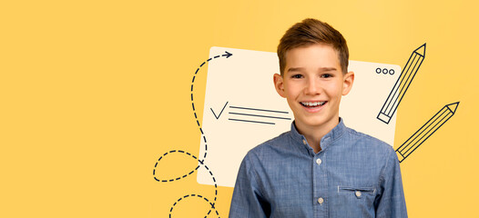 A handsome teen boy smiles while looking at the camera on a yellow background. He wears a denim shirt and stands next to school supplies. His expression shows happiness and energy. © Prostock-studio