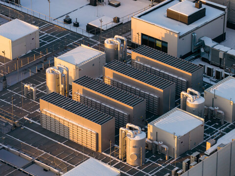 Aerial view of a data center rooftop showing cooling and ventilation systems, network infrastructure, and compute grid, Warszawa, Wojewodztwo mazowieckie, Poland.
