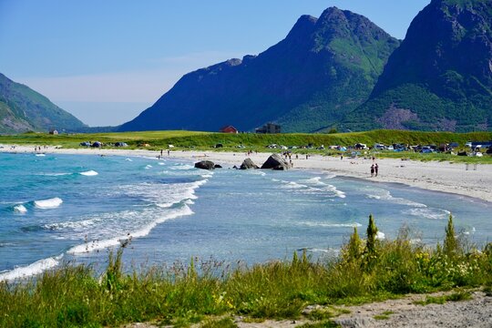Tourists enjoy the crystal clear waters at Skagsanden beach in Lofoten, Norway.