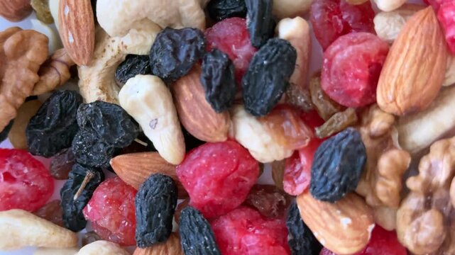 Rotating close-up of mixed nuts and dried fruit, organic superfoods against a backdrop of healthy eating, culinary design, and healthy eating concepts
