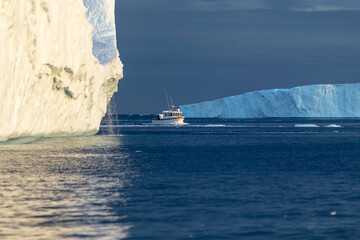Tour Boat Navigating Between Massive Icebergs in Disco Bay, Greenland - Arctic Ocean Adventure © Katrin