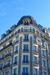 Fototapeta premium Typical parisian building with french balconies on sunny day, Haussmann period architecture. Apartments in old houses, renovation of city