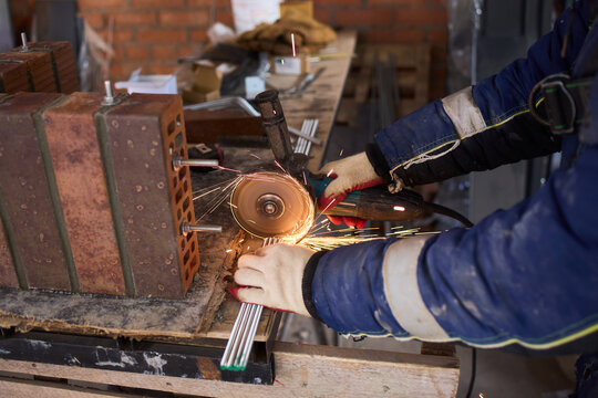 Worker sparks grinding. Steel bar being grinded carefully. Industrial worker shaping metal with grinder. Grinder sparks fly as worker shapes sturdy steel reinforcement bar