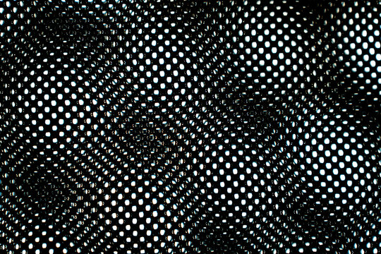 Background texture of black mesh fabric in close-up view. Detailed macro shot revealing intricate weave pattern and dimensional surface of the material.