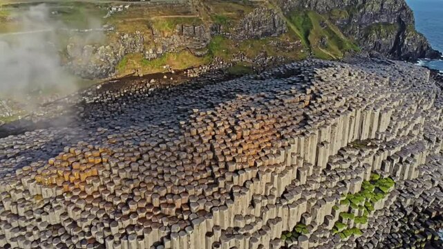 Epic drone footage flying over Giants Causeway ancient volcanic rock columns dynamic coastal landscape ireland