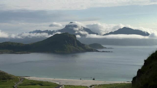 Cinematic panoramic footage of the stunning Haukland Beach coastline with turquoise sea, white sand, and dramatic mountain peaks in Lofoten, Norway