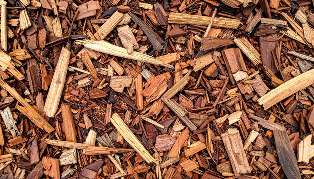 Natural wood chip mulch texture background featuring organic bark pieces in warm brown tones. Ideal for landscaping, gardening themes, eco design projects and seamless natural surface use.