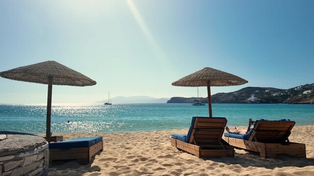 View of a person relaxing and sunbathing at the wonderful sandy beach of Mylopotas in Ios Greece