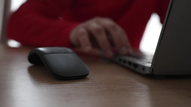 Close-up of a mans hand on a mouse, then moving away and starting to type on a laptop keyboard. Natural workflow transition. Concept of office routine, digital tasks and focused computer work