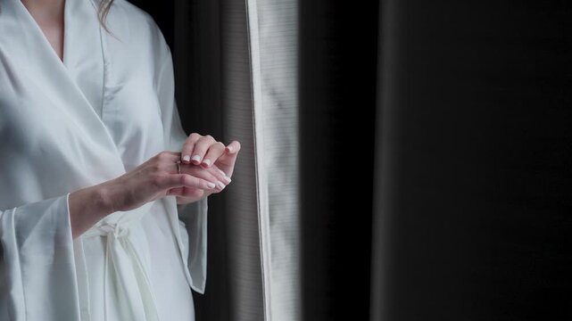 The bride holds a wedding ring in her hands