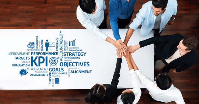 A diverse team collaborates around a table, focusing on key performance indicators and strategic goals, enhancing business efficiency and aligning objectives for success. Amity