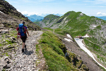 A woman and her dog hiking from mount Faulhorn to Schynige Platte