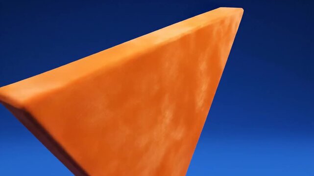Orange Triangle Geometric Shape Rotating on Blue Background Abstract 3D Animation.