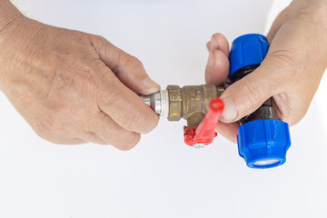 A close-up of hands applying white Teflon tape to seal the threads of a metal fitting during a plumbing repair.