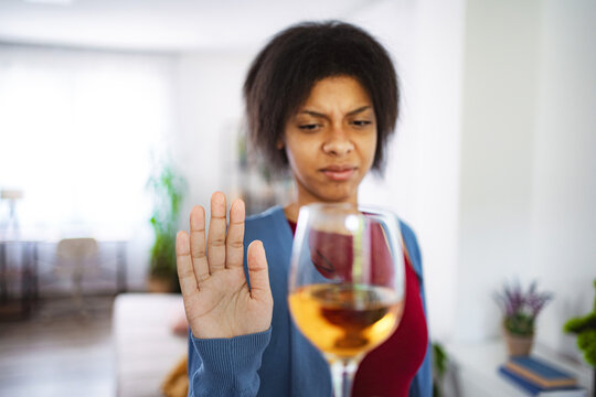 Young woman refusing a glass of wine at home