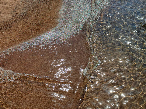 Sea waves on sandy beach.