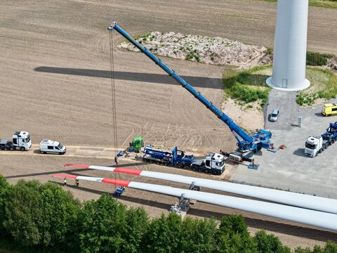 Kram verl&auml;dt Rotorblatt f&uuml;r eine Windkraftanlage, Windradfl&uuml;gel, Luftbild, Schwertransport, Baustelle, Logistik, Energiewende