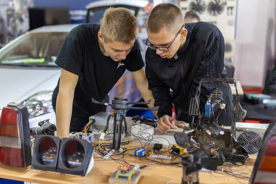 Students examining car electronics and engineering components
