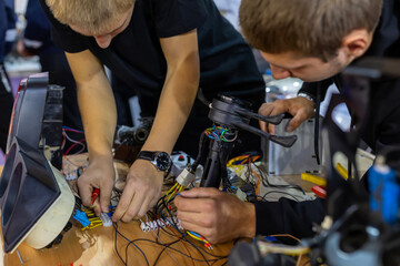 Obraz premium Young men connecting intricate wiring during an electronics workshop