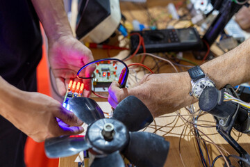 Obraz premium People building electronic circuit with hands-on approach