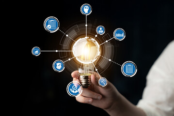 A conceptual image featuring a light bulb held in hand, surrounded by digital icons symbolizing...