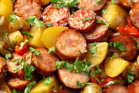 Roasted Potato and Sausage in frying pan on dark wooden table