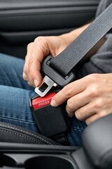 Person Fastening Seatbelt in Car While Sitting in Drivers Seat During Daytime