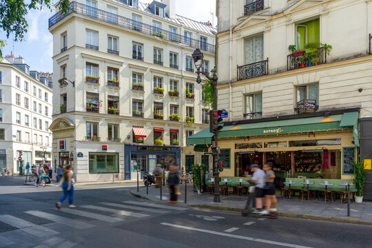 Paris, France - July 13, 2019: Charming Parisian Street Corner with Traditional Corner Bistro and Classic Haussmann Architecture in Le Marais