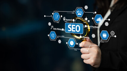 Fototapeta premium A hand holds a magnifying glass over an SEO graphic, surrounded by technology icons representing data analysis and marketing strategies for effective business growth. Tessel